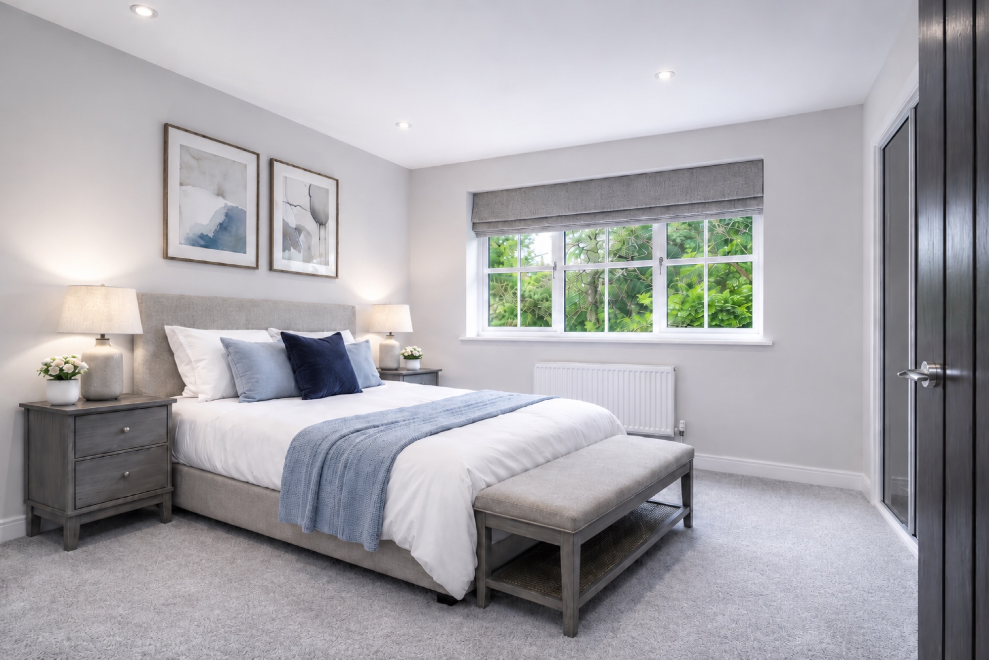 Secondary bedroom finished in soft grey tones with blue accent cushions and throw